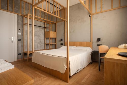 a bedroom with a bed with a wooden frame at Re Versiliana Hotel in Marina di Pietrasanta