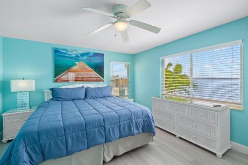 1 dormitorio azul con 1 cama y ventilador de techo en Serenity & Sunrises, en Cabo Coral