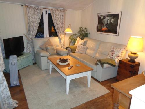 a living room with a couch and a coffee table at Log Cabin, Conveniently Situated halfway between Stratford and Warwick in Stratford-upon-Avon