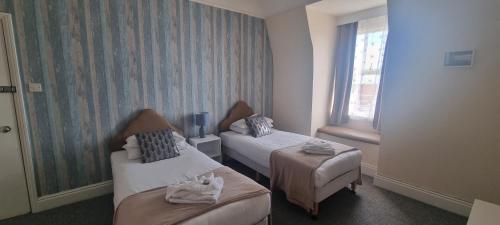 a hotel room with two beds and a window at Royal Pier in Sandown