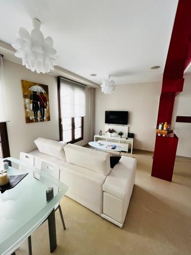 a living room with a white couch and a table at Duplex en Casco Histórico in León