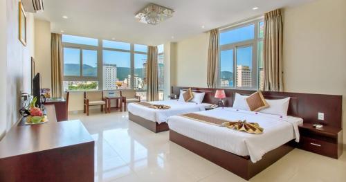 Sunview Beach Hotel Danang في دا نانغ: غرفة فندقية بسريرين وطاولة وكراسي