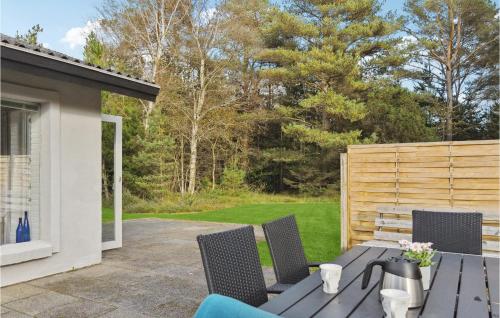 a patio with a table and chairs and a fence at 3 Bedroom Amazing Home In Ålbæk in Ålbæk