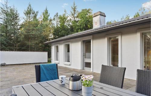 a table and chairs on a patio with a house at 3 Bedroom Amazing Home In Ålbæk in Ålbæk