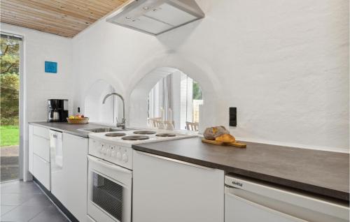 a white kitchen with a white stove top oven at 3 Bedroom Amazing Home In Ålbæk in Ålbæk