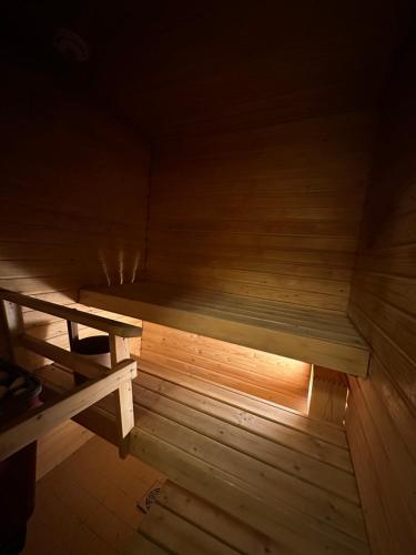 an empty sauna with a wooden floor and a bench at Lapinmaa Apartments in Rovaniemi