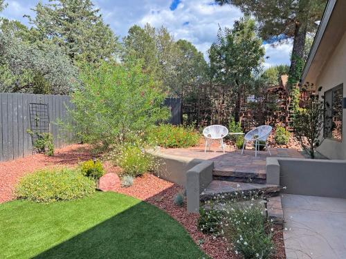 a backyard with a patio with two chairs and a lawn at Modern Luxury Home in West Sedona with Hot Tub in Sedona