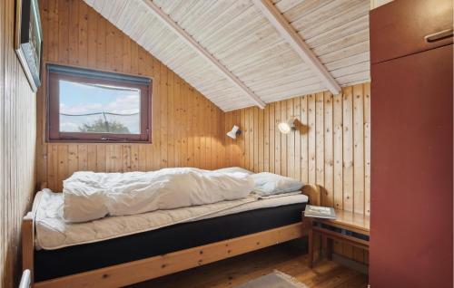 een bed in een houten kamer met een raam bij 3 Bedroom Amazing Home In Hejls in Hejls