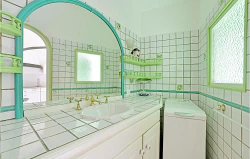 a bathroom with a tub and a sink and a mirror at Beautiful Home In La Grande-motte With Kitchen in La Grande-Motte