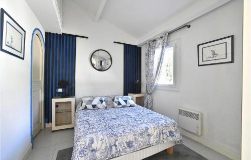 1 dormitorio con cama y espejo en la pared en Beautiful Home In La Grande-motte With Kitchen, en La Grande-Motte