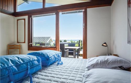 een slaapkamer met 2 bedden en een groot raam bij Beautiful Home In Hejls With House Sea View in Hejls
