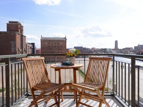 a table and two chairs on a balcony with a view at Ohlerich Speicher App_ 10 in Wismar