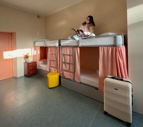a woman in a room with two bunk beds at Demeevsky Hostel in Kyiv