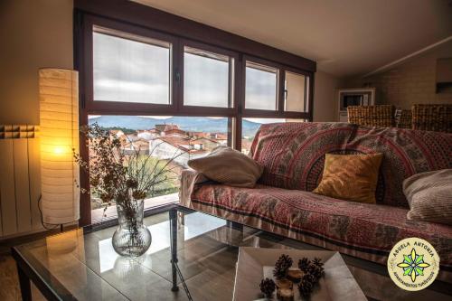 a living room with a couch and a large window at AT la Abuela Antonia-El Gurugú in Torre de Don Miguel