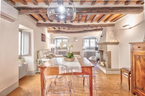 a dining room with a table and a fireplace at Casa Samuela - Together in Tuscany in Cortona