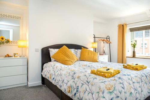 a bedroom with a large bed with yellow pillows at Country Cottage in quaint Village, sleeps 3 in Bere Alston