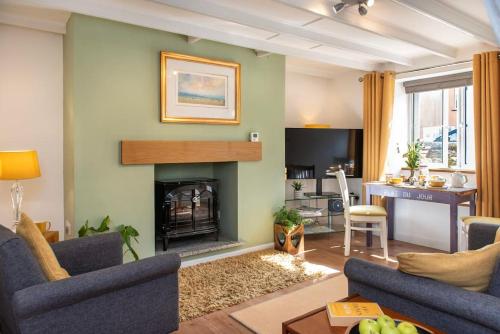 a living room with a fireplace and a table at Country Cottage - Apple Pie Luxury Escapes in Bere Alston