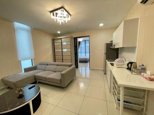 a living room with a couch and a table in a kitchen at H2O Residences Ara Damansara PJ with WiFi Washing Machine and Dryer in Petaling Jaya