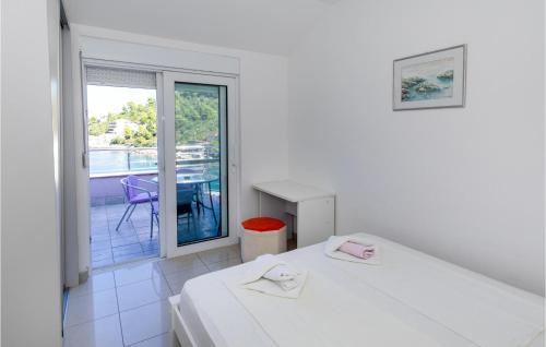 Dieses weiße Zimmer verfügt über 2 Betten und einen Balkon. in der Unterkunft Stunning Apartment In Blace With House Sea View in Blace