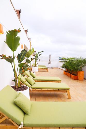 a room with green couches and potted plants at Hotel Boutique Balandret in Valencia