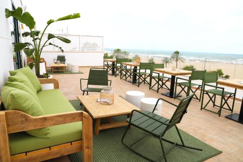 a patio with tables and chairs and a beach at Hotel Boutique Balandret in Valencia