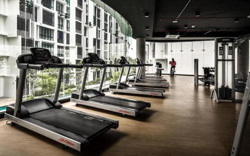 una fila de cintas de correr en un gimnasio en un edificio en H2O Residences Ara Damansara PJ, en Petaling Jaya