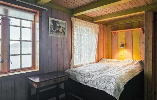1 dormitorio con cama, ventana y mesa en Stunning Home In Mosvik With House Sea View, en Mosvik