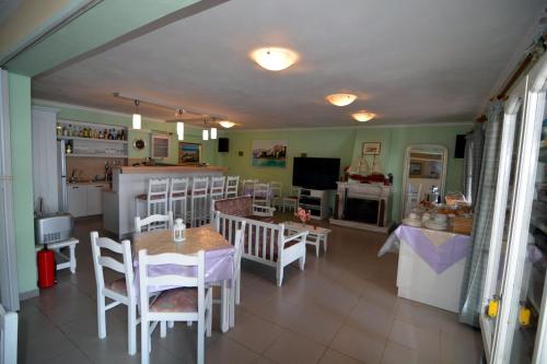 Una cocina y un comedor con mesa y sillas. en Stella Hotel Apartments, en Fiskardho
