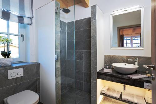 een badkamer met een wastafel, een toilet en een spiegel bij Hochalmbahnen Chalets Rauris 1-04, Maislaufeldweg 1d in Rauris