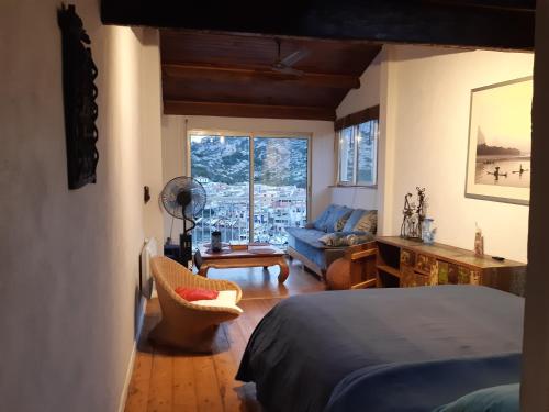 a bedroom with a bed and a couch and a window at Maison Vue mer et calanques Les Goudes in Marseille