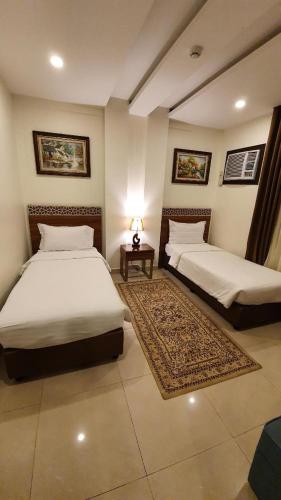 a bedroom with two beds and a table with a lamp at منتجع شاطئ الدولفين للإيواء السياحي in Yanbu