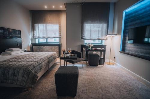 a bedroom with a bed and a table and a tv at Boutique Hotel Townhouse 27 in Belgrade