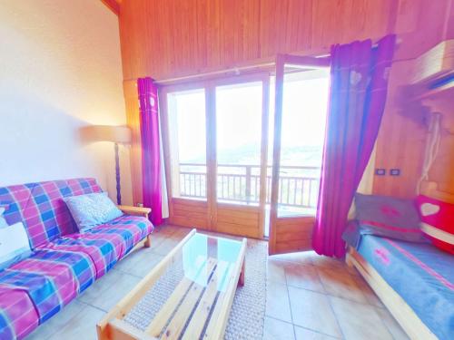 un salon avec un canapé et une grande fenêtre dans l'établissement Appartement 3 pièces familial - Les Saisies - FR-1-594-45, à Hauteluce