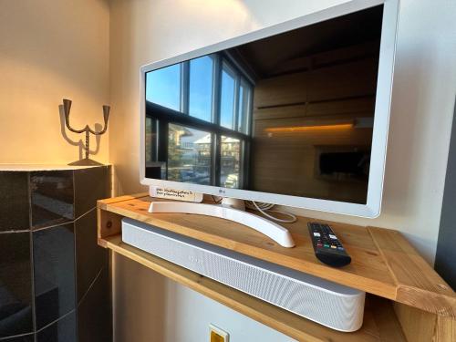 a television on a wooden table with a remote control at HolySuites 2 - Ski-in and out apartment in the middle of ski slopes in Pyhä in Pyhätunturi
