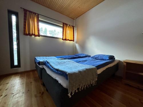 a bedroom with a bed with blue sheets and a window at HolySuites 2 - Ski-in and out apartment in the middle of ski slopes in Pyhä in Pyhätunturi