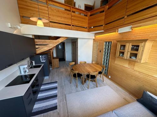 an open kitchen and dining room with a wooden ceiling at HolySuites 2 - Ski-in and out apartment in the middle of ski slopes in Pyhä in Pyhätunturi