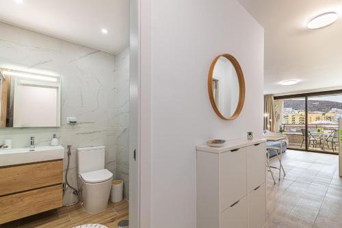 a bathroom with a toilet and a sink and a mirror at Valdes Center Los Cristianos in Los Cristianos