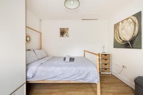 um quarto com uma cama e um relógio na parede em 1BD Apartment near Olympic Park, East London em Londres