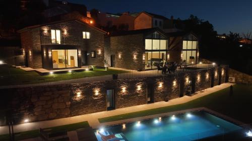una casa iluminada por la noche con una piscina en SERRA en Cortes do Meio