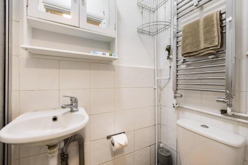 Baño blanco con lavabo y aseo en 1BD Apartment near Olympic Park, East London en Londres