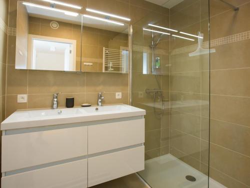 uma casa de banho com um lavatório e um chuveiro em Riva spacious and modern with top location em Middelkerke