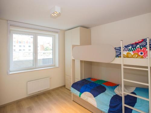 um pequeno quarto com um beliche e uma janela em Riva spacious and modern with top location em Middelkerke