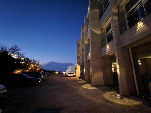 a street with cars parked next to buildings at night at Hotel Hue Loft in Incheon