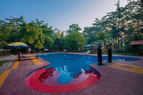 una piscina con un rosso bianco e blu di Jungle King Resort a Kanha