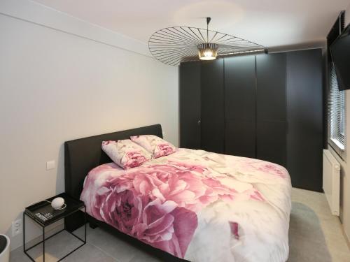 ミッデルケルケにあるApartment in Belgium with Sunny Terraceのベッドルーム1室(ピンクの花が咲くベッド1台付)