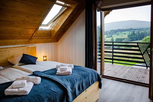 ein Schlafzimmer mit einem Bett und einem großen Fenster in der Unterkunft Domek Kordoń SPA Jacuzzi & Sauna in Zubrzyca Górna