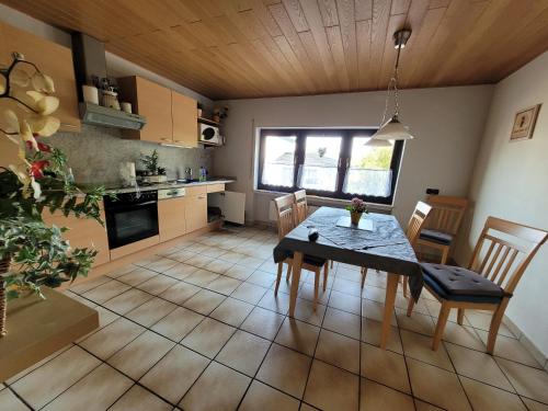 eine Küche und ein Esszimmer mit einem Tisch und Stühlen in der Unterkunft Eifelferienhaus Thome in Lissendorf