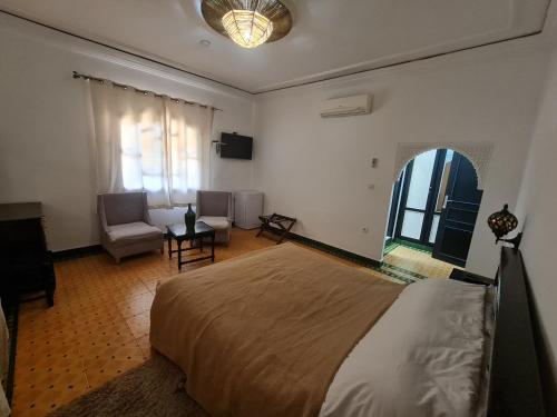 a bedroom with a bed and a living room at Targafit Hotel & Hammam in Marrakech