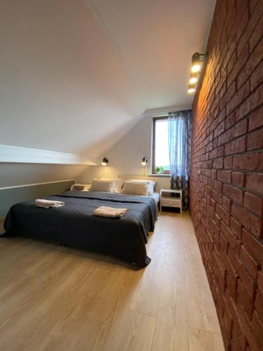 a bedroom with two beds and a brick wall at Polana in Lipowiec