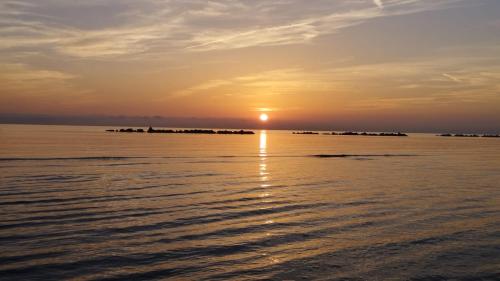 a sunset over the water with a group of islands in the distance at Atlantic Roseto sul mare in Roseto degli Abruzzi